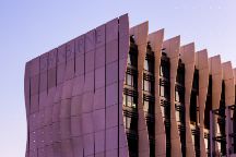 Sunset view of Swinburne's Advanced Manufacturing and Design Centre (AMDC) building, with warm orange and pink hues painting the sky behind it.