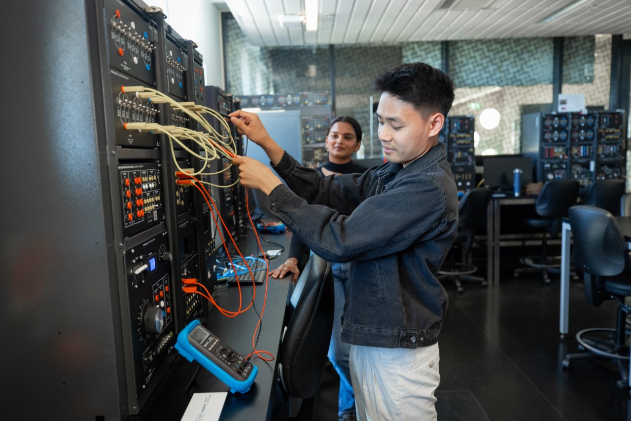 Two students using Festo LabVolt hardware, plugging wires in to explore electrical circuits.