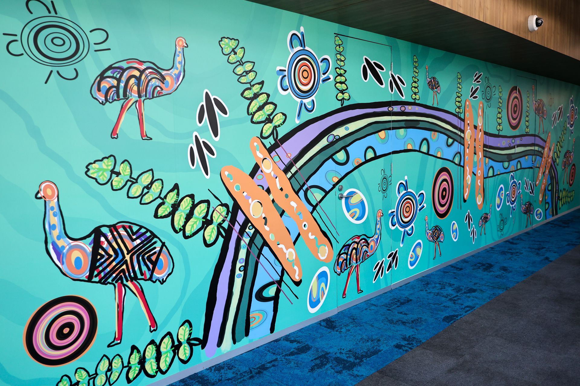 AGSE Artwork 1 Indigenous artwork by Mandi Barton, featuring emus, bright colours and flowing lines along a wall.