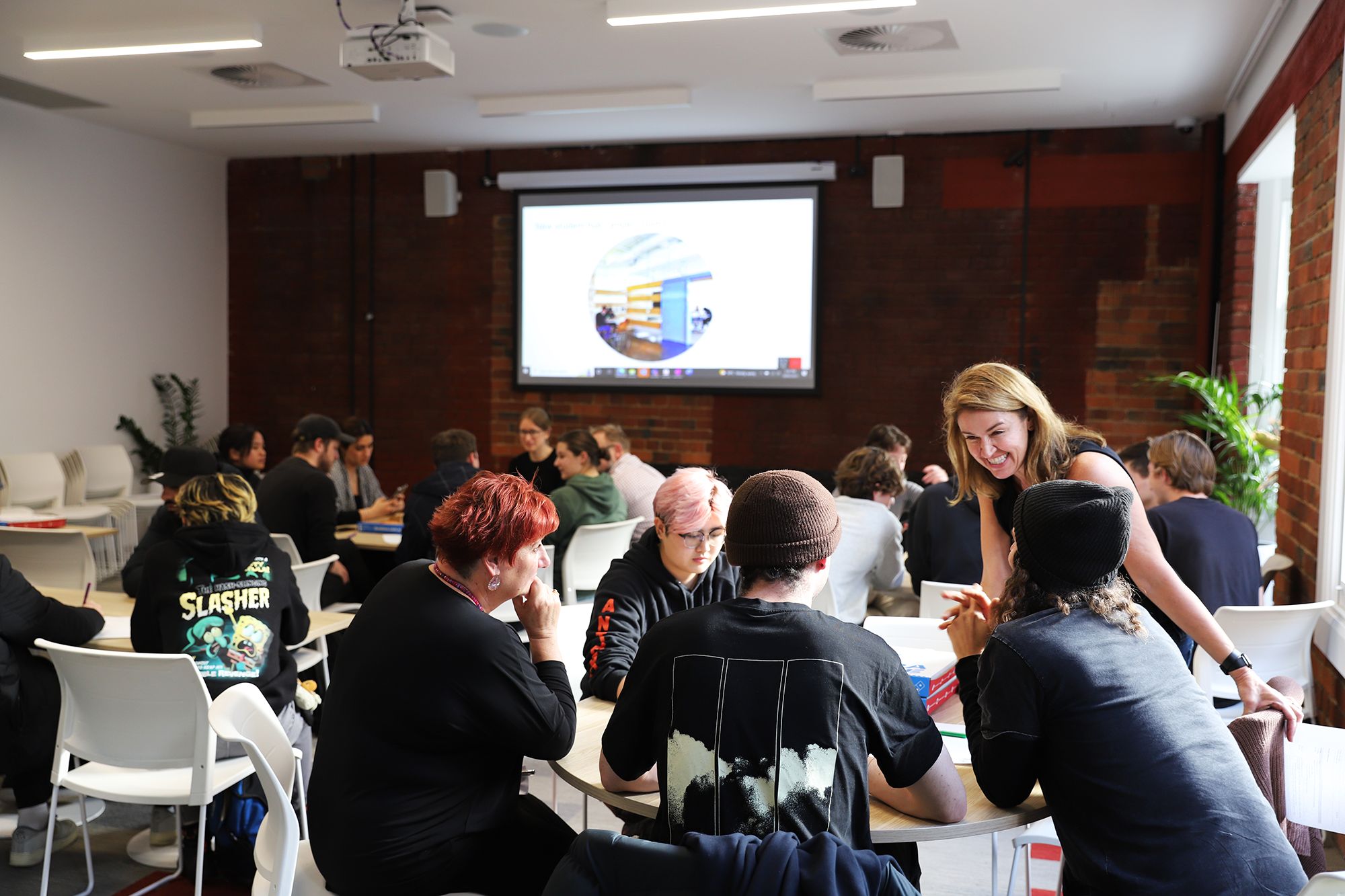 Students gather around tables and have discussions