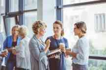 Women engaging in discussion at a corporate networking event.