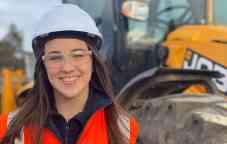 Photograph of Decmil professional placement student Kelsey Ingham wearing a hard hat and safety vest on a construction site.