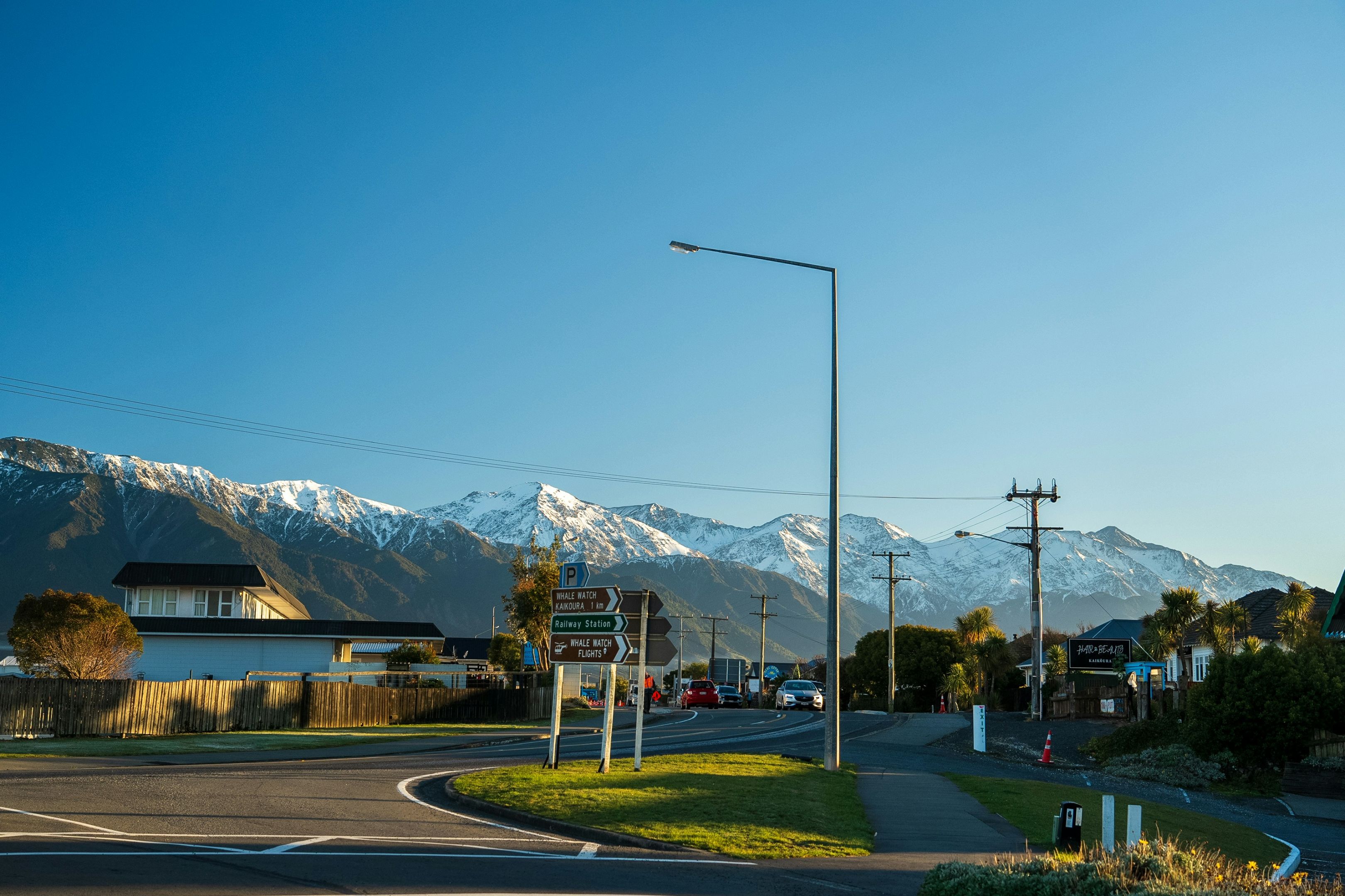 Aoteroa - New Zealand Scenic view of a road in a small town with snow capped mountains behind