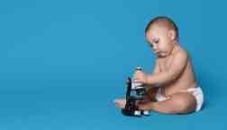 Adorable baby boy with microscope.