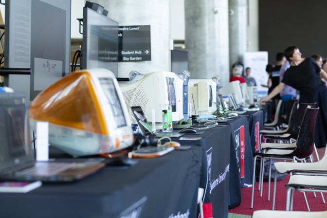 Side-by-Side A table with rows of old computers being emulated onto modern laptops.