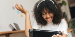 Woman playing a video game on the Nintendo Switch and wearing headphones