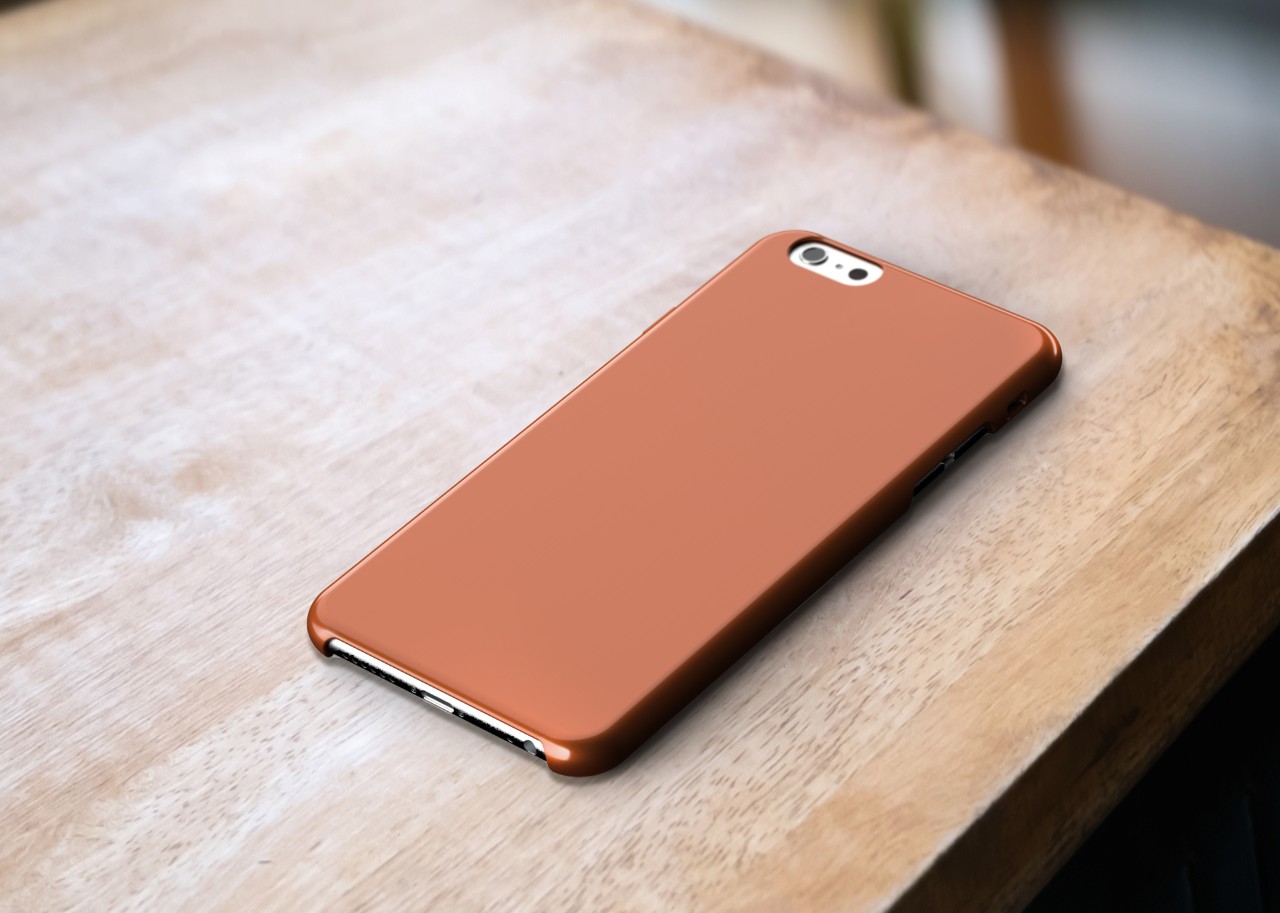 A mockup of a copper phone case sitting on a wooden table, no wear