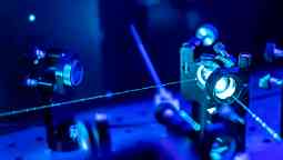 Laser reflection on optic table in quantum laboratory.