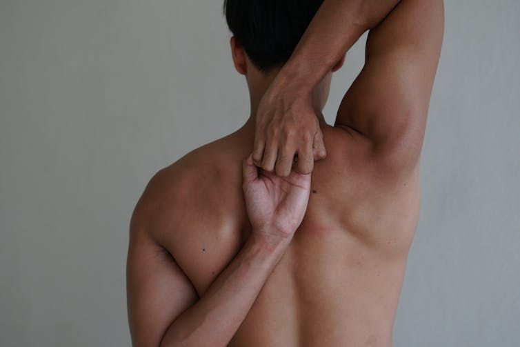 Flexibility in the shoulder joint Man with his hands behind his back, performing a shoulder stretch
