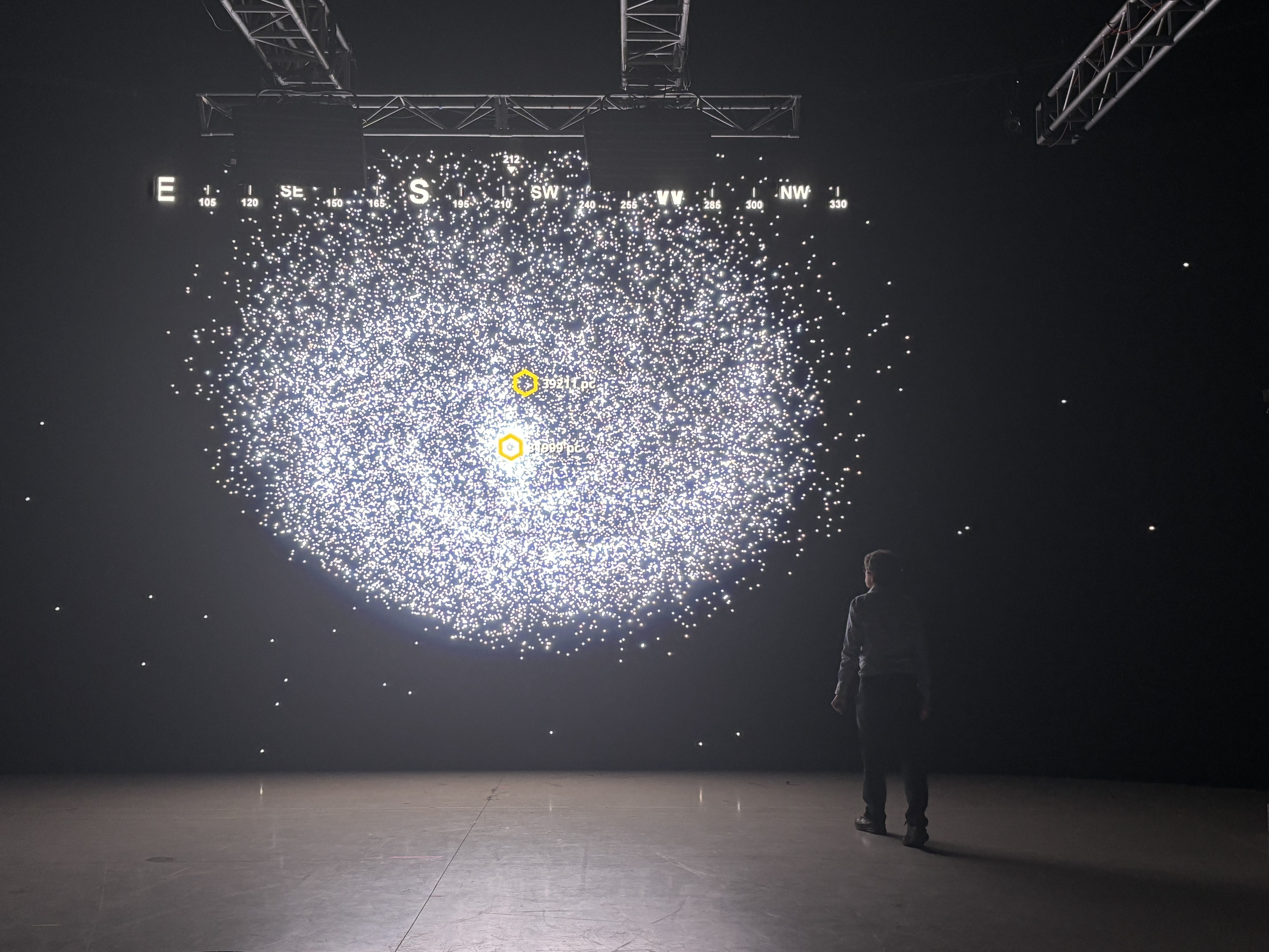 man looking at projection of a solar system in a dark room