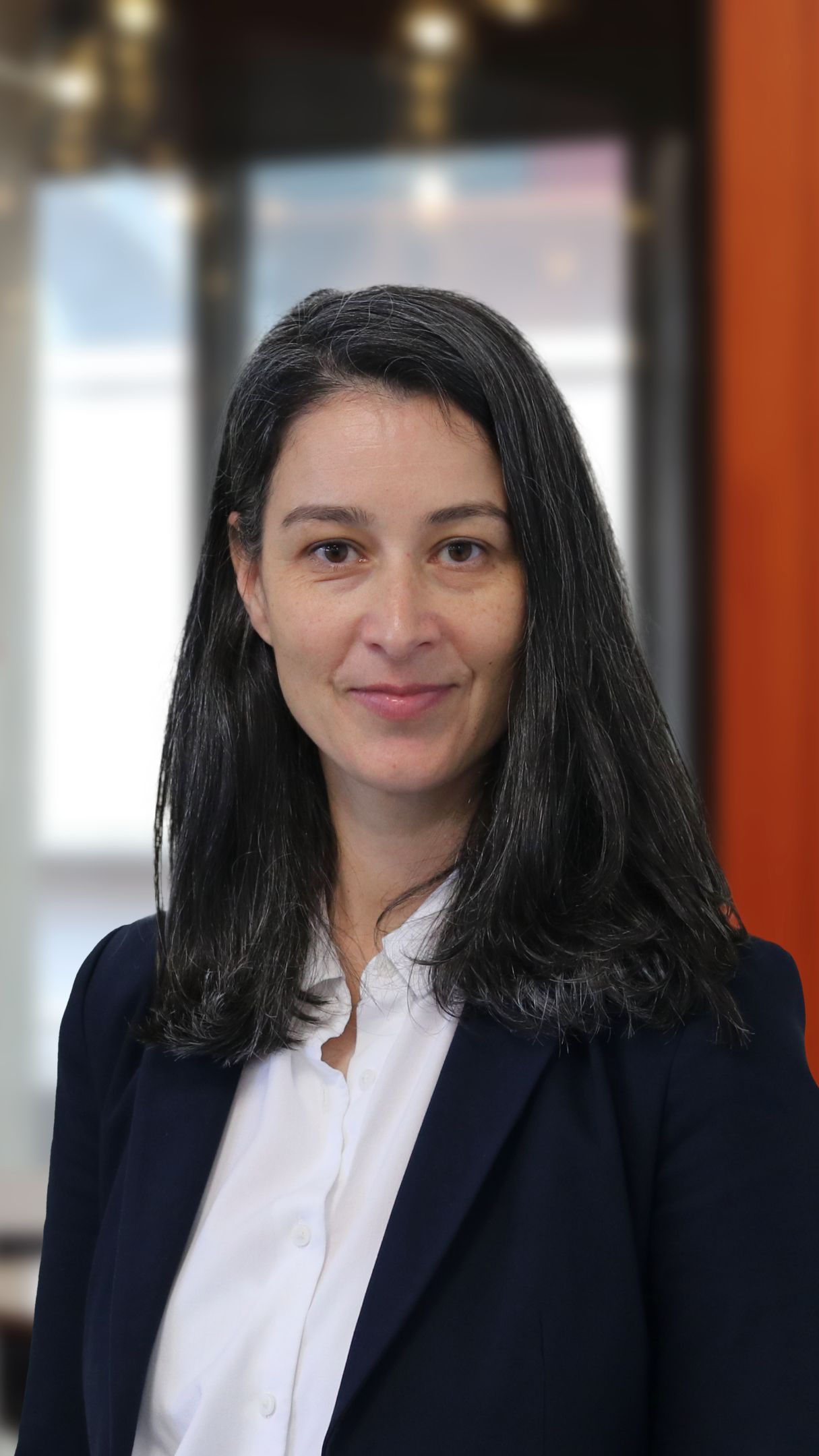 Woman in a black blazer smiling for the camera