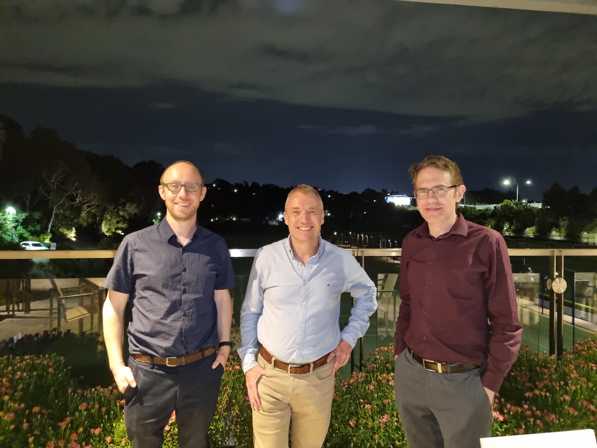 Associate Professor Tim Bednall, Paul Lund and Dr Ben Williams stand together on a balcony.