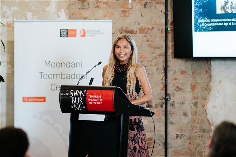 Woman standing behind a lectern smiling 