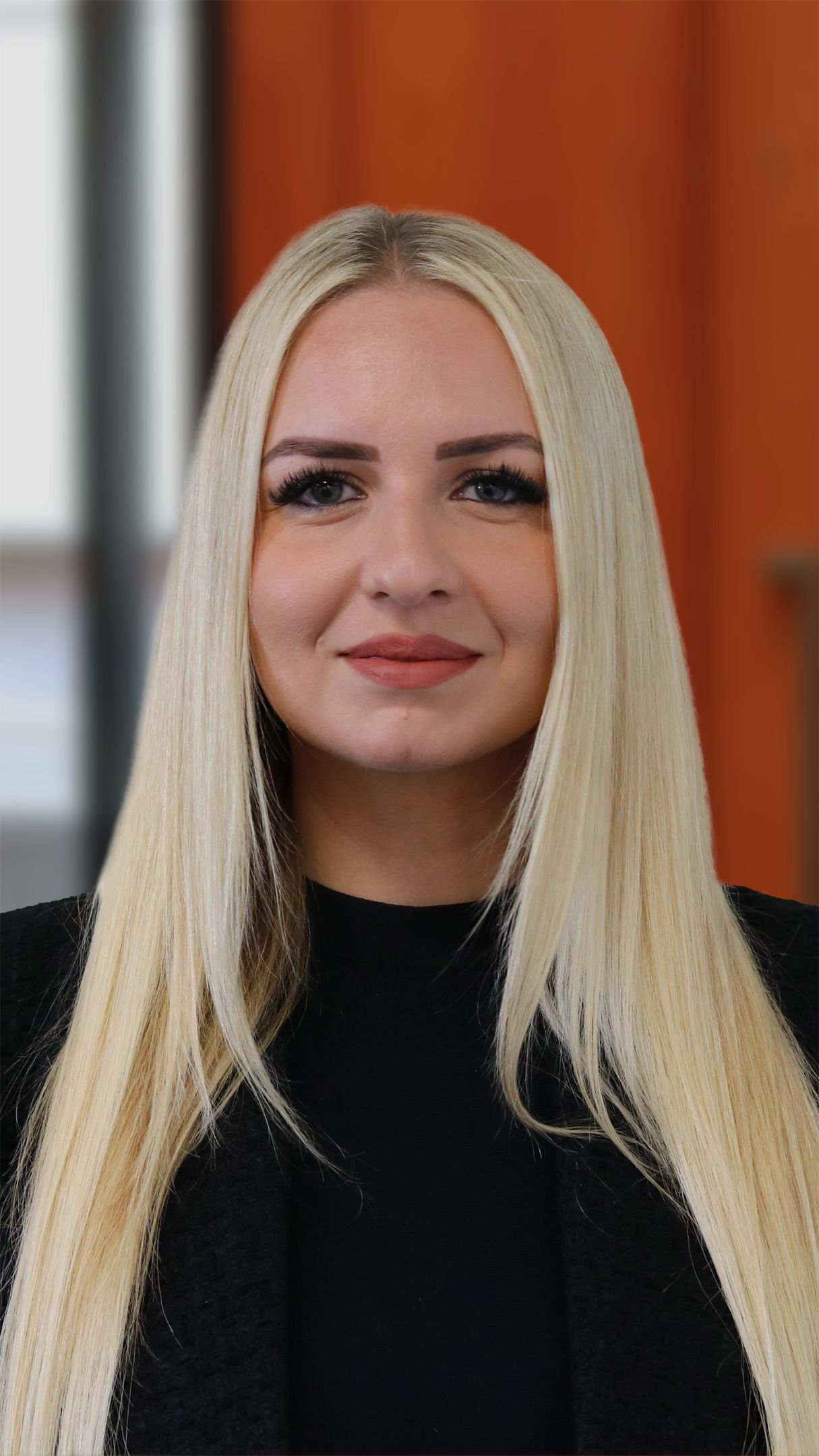 Close up of a woman with blonde hair smiling for the camera