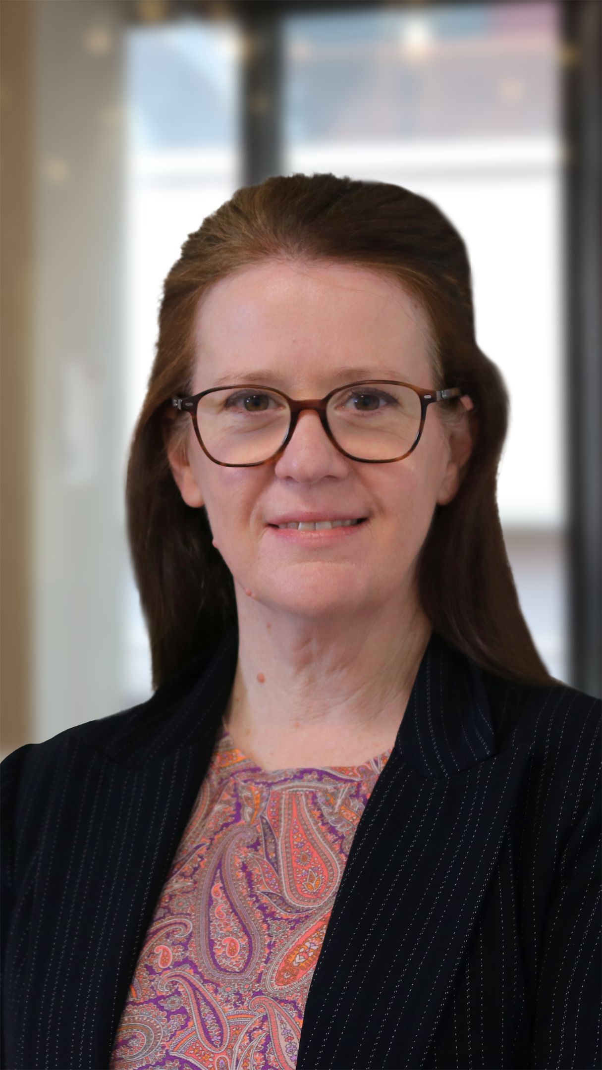 Woman with long brown hair and glasses smiling for the camera 