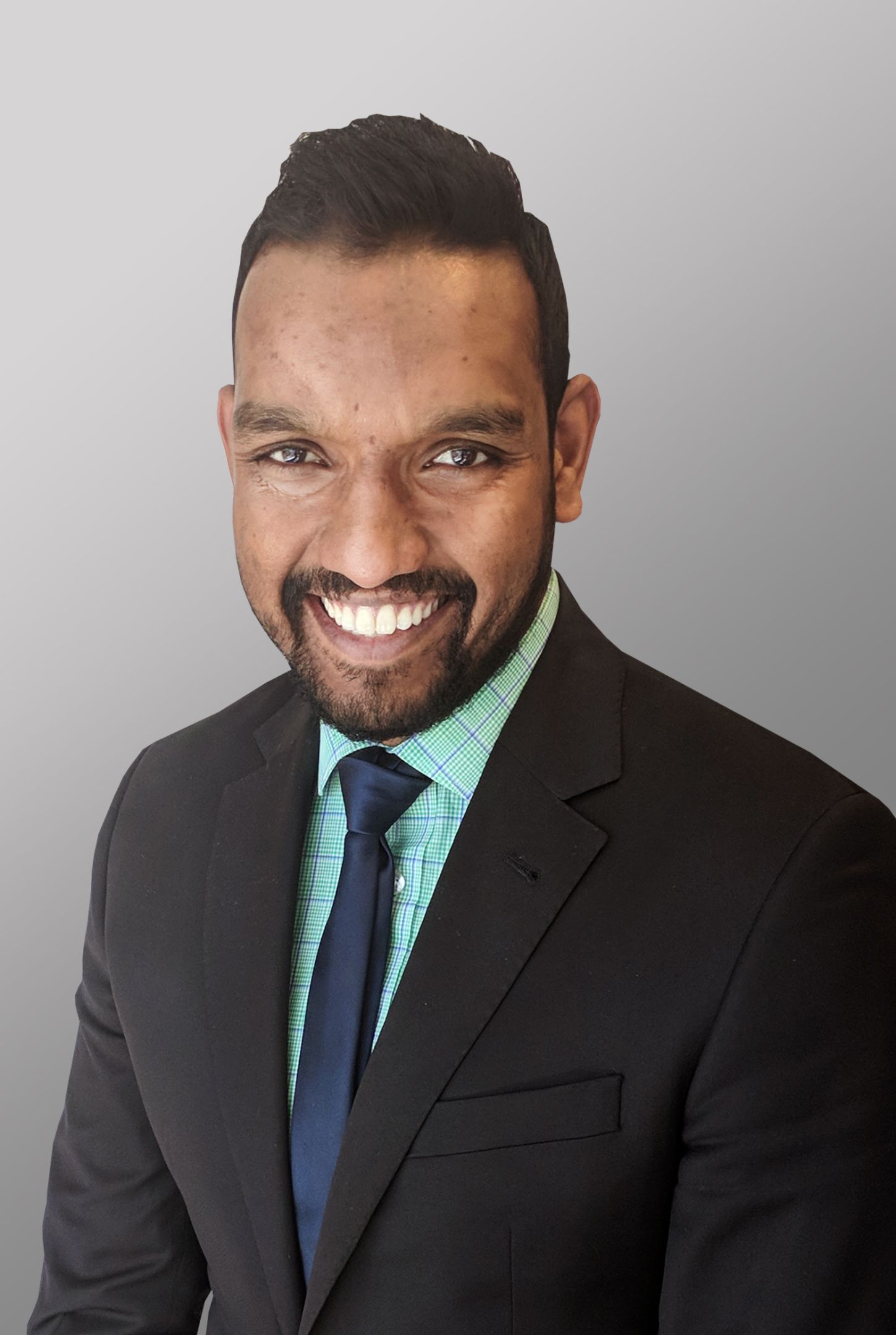 A professional looking man wearing a suit and tie is smiling.