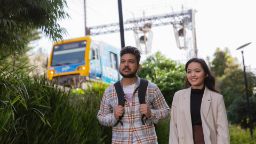 Two international students walking next to the train track on Swinburne's Hawthorn campus