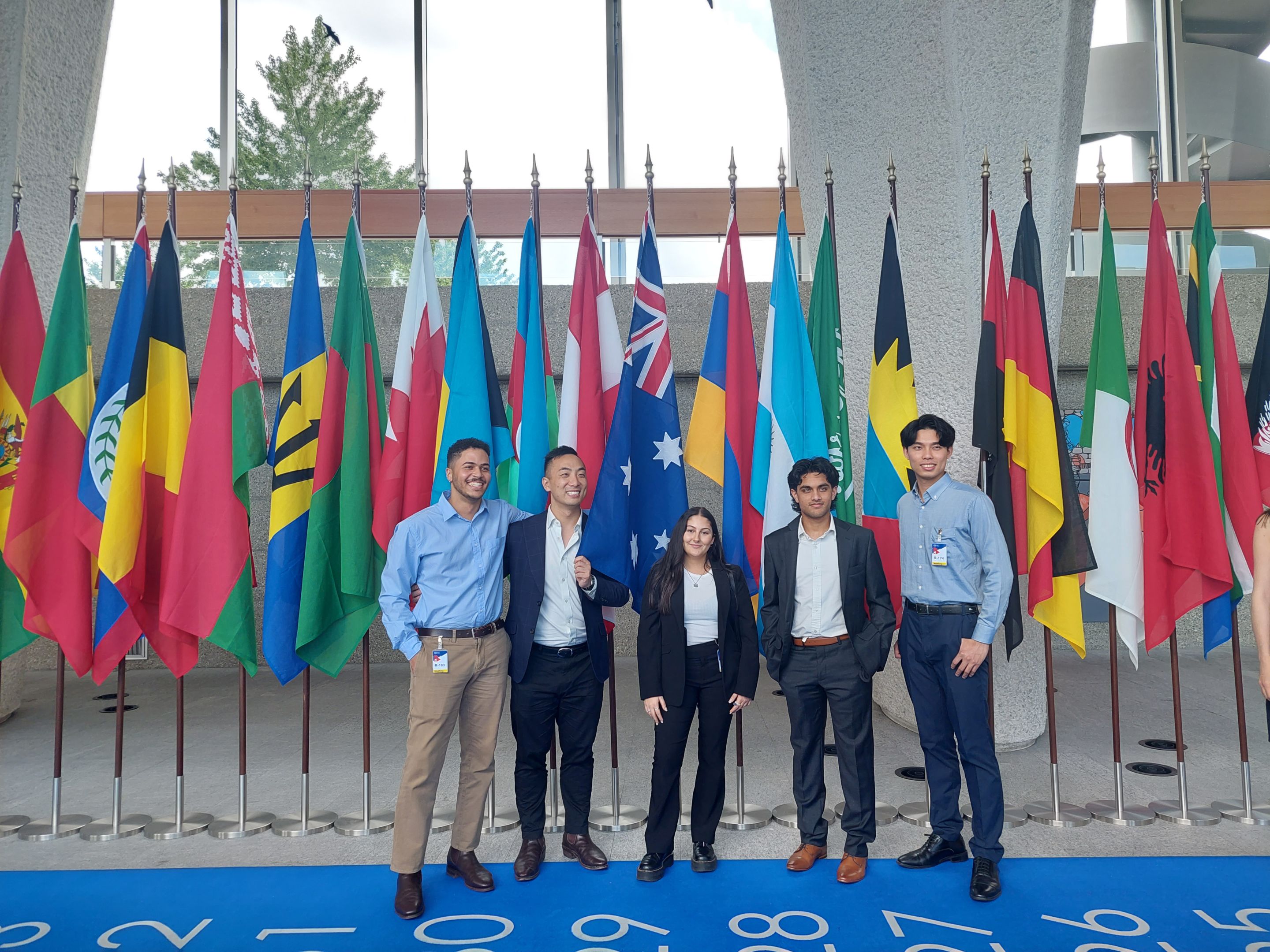 HEG Fribourg Summer School 2024 in Switzerland. Image of students standing in front of international flags.