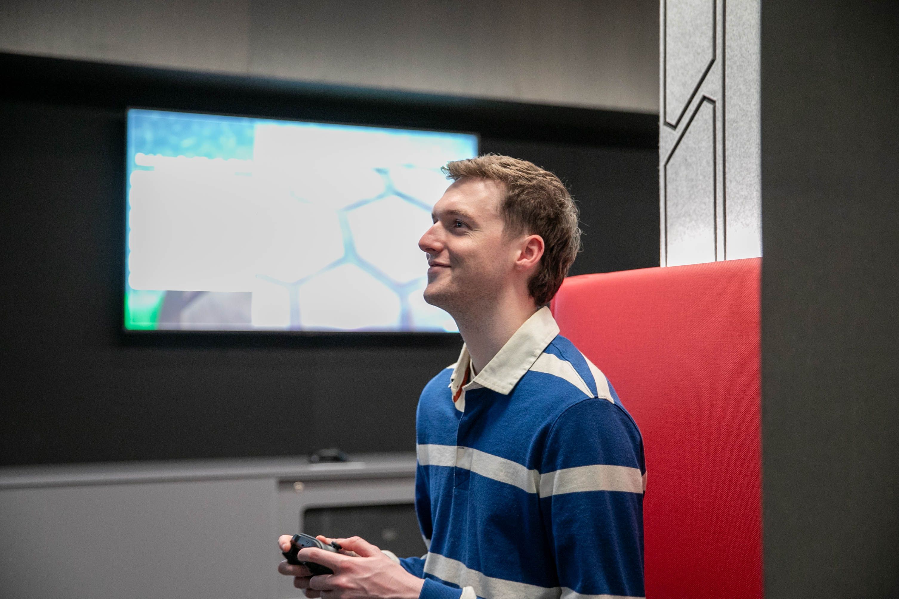 Scholarship student Oliver Sexton is studying a Bachelor of Games and Interactivity and is pictured here playing a video game in Swinburne's media lab