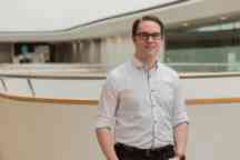 young man neatly dressed with glasses in modern internal location