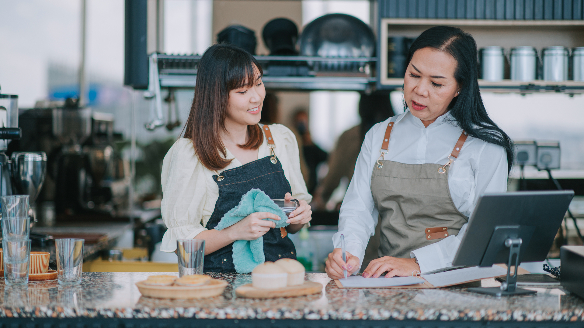 Two cafe workers behind a counter