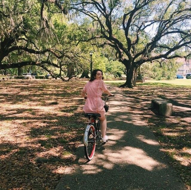 Woman riding a bike through a park