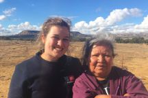 Amy outside in the country side with a women smiling at the camera on a sunny and windy day