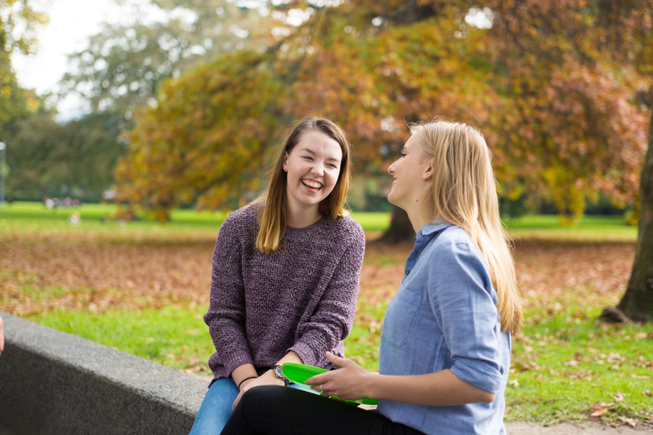 Two students socialising in the park with a frisbee