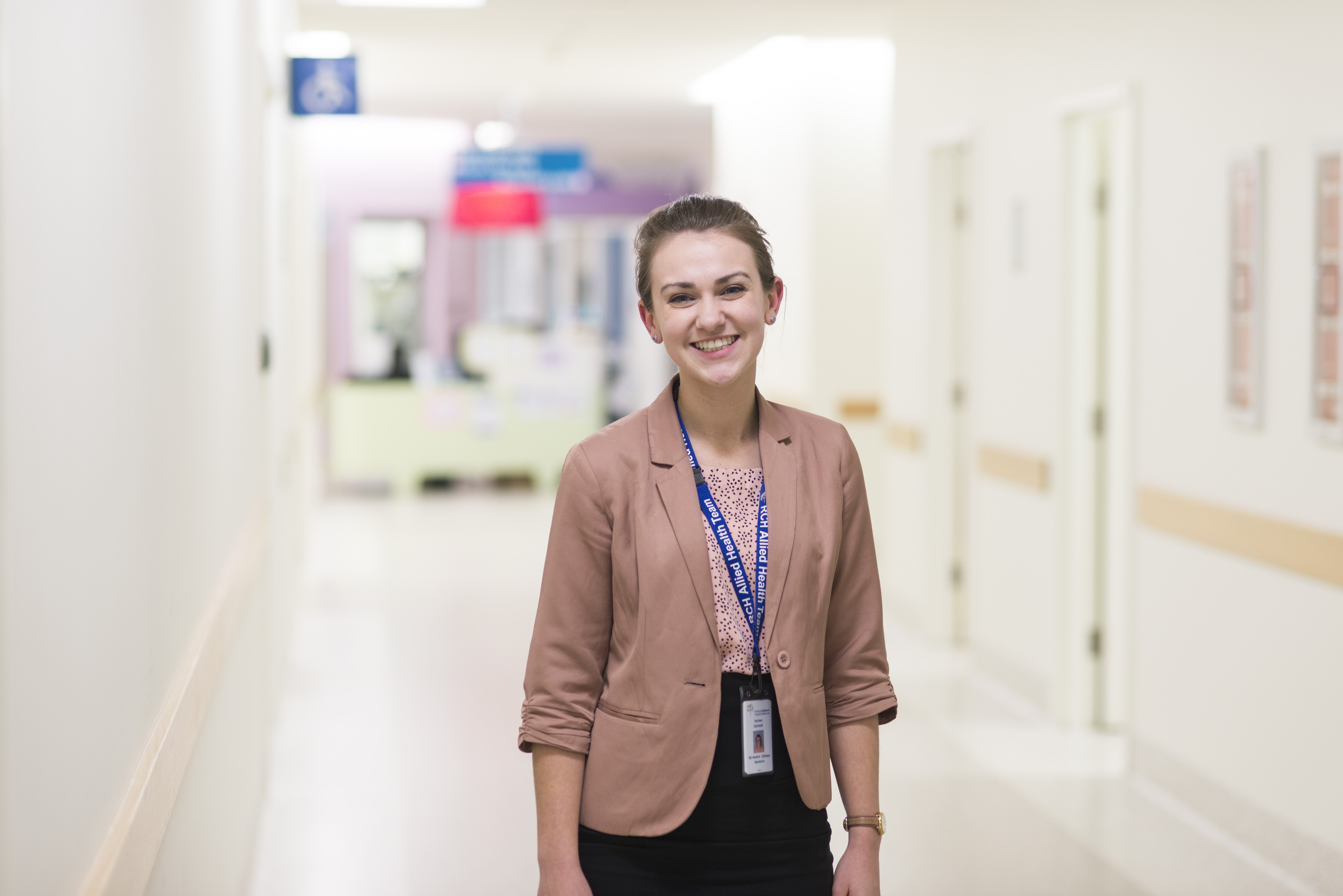 A Swinburne student on placement standing in a hospital hallway.