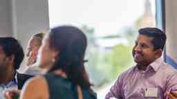 A professional looking man sits among a group of other students in a training session.