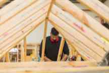 Building and Construction area with male student building a roof