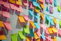 A variety of ideas written on colourful post-it notes stuck onto a white background