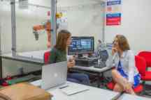 Two female students discuss robotics in the classroom