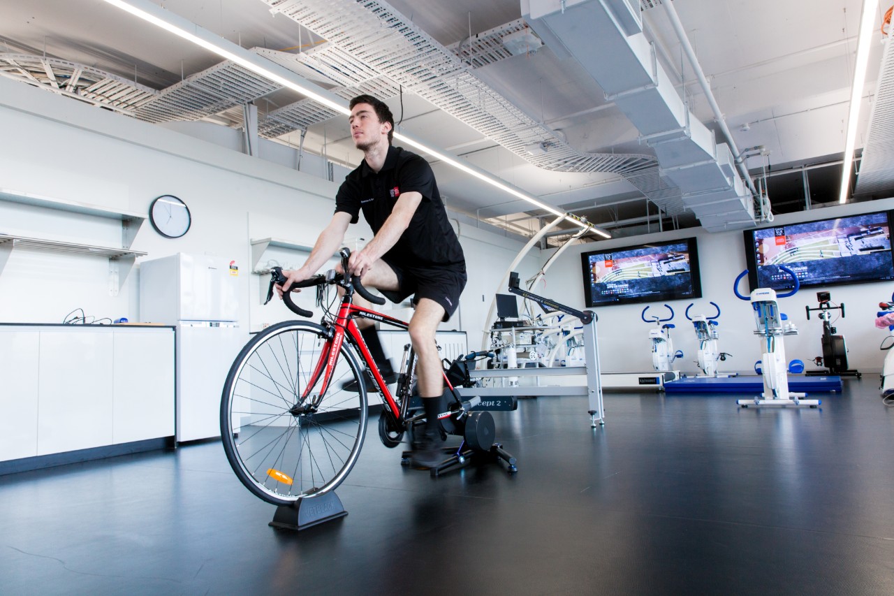 Male student wearing Swinburne apparel using a specialised exercise bike